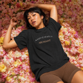 Black crewneck T-shirt with centered “AUSPICIOUSLY ABUNDANT” text graphic.