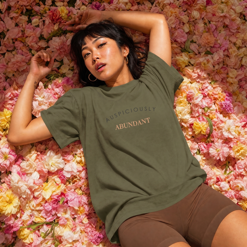 Military green crewneck T-shirt with “AUSPICIOUSLY ABUNDANT” text graphic on the front.