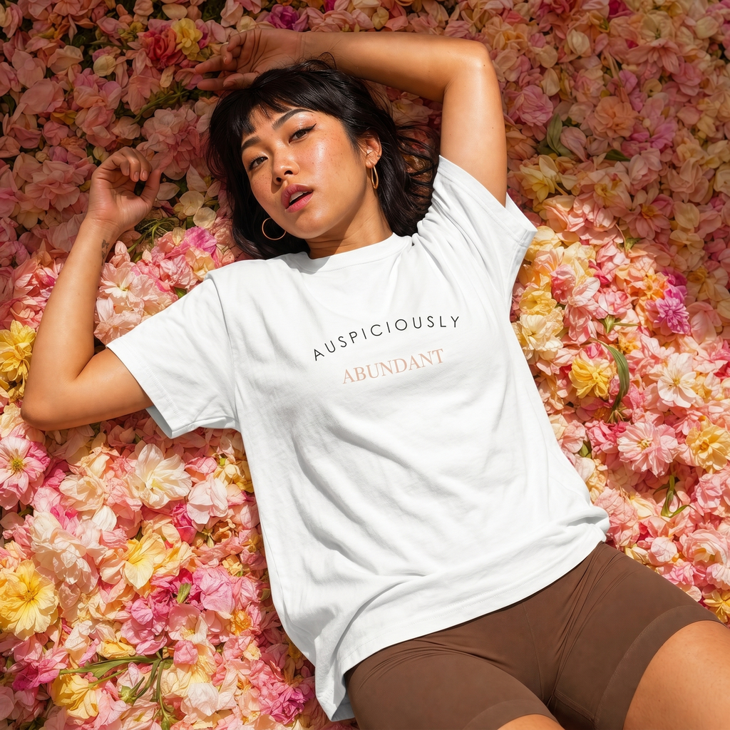 White crewneck T-shirt with “AUSPICIOUSLY ABUNDANT” text graphic on the front.