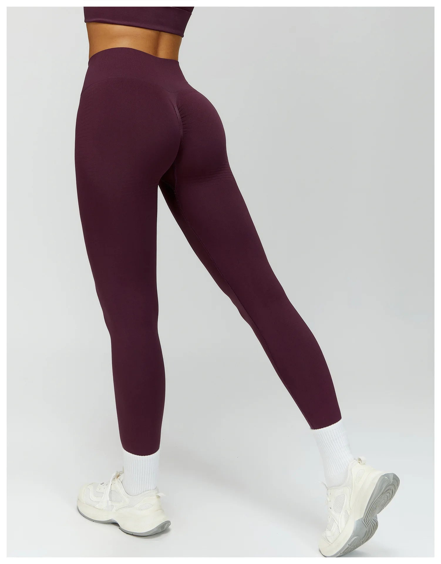 Plum purple high-waisted active leggings, angled side view of fitted legs