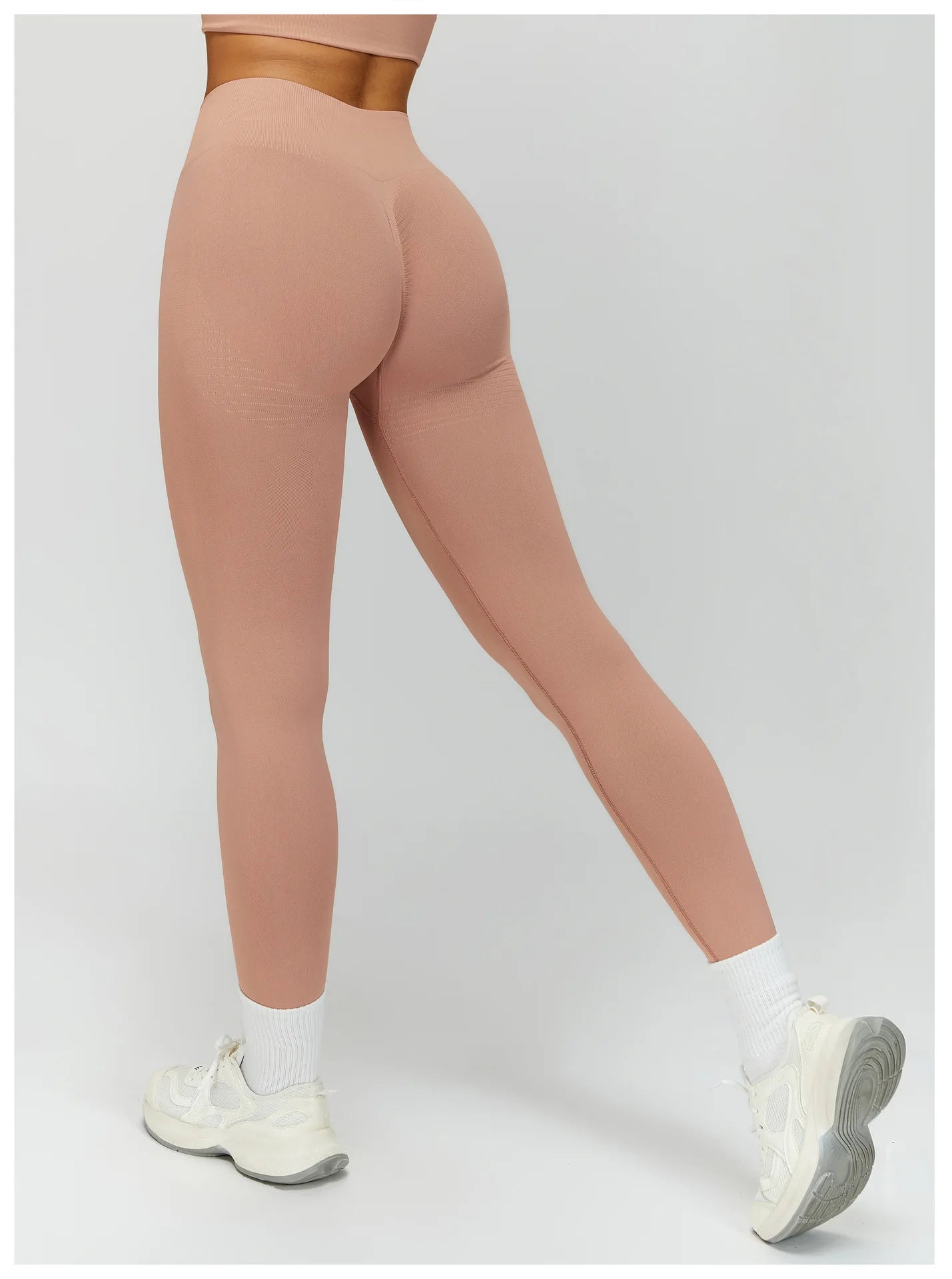 Peach pink high-waisted active leggings, side view with fitted straight leg