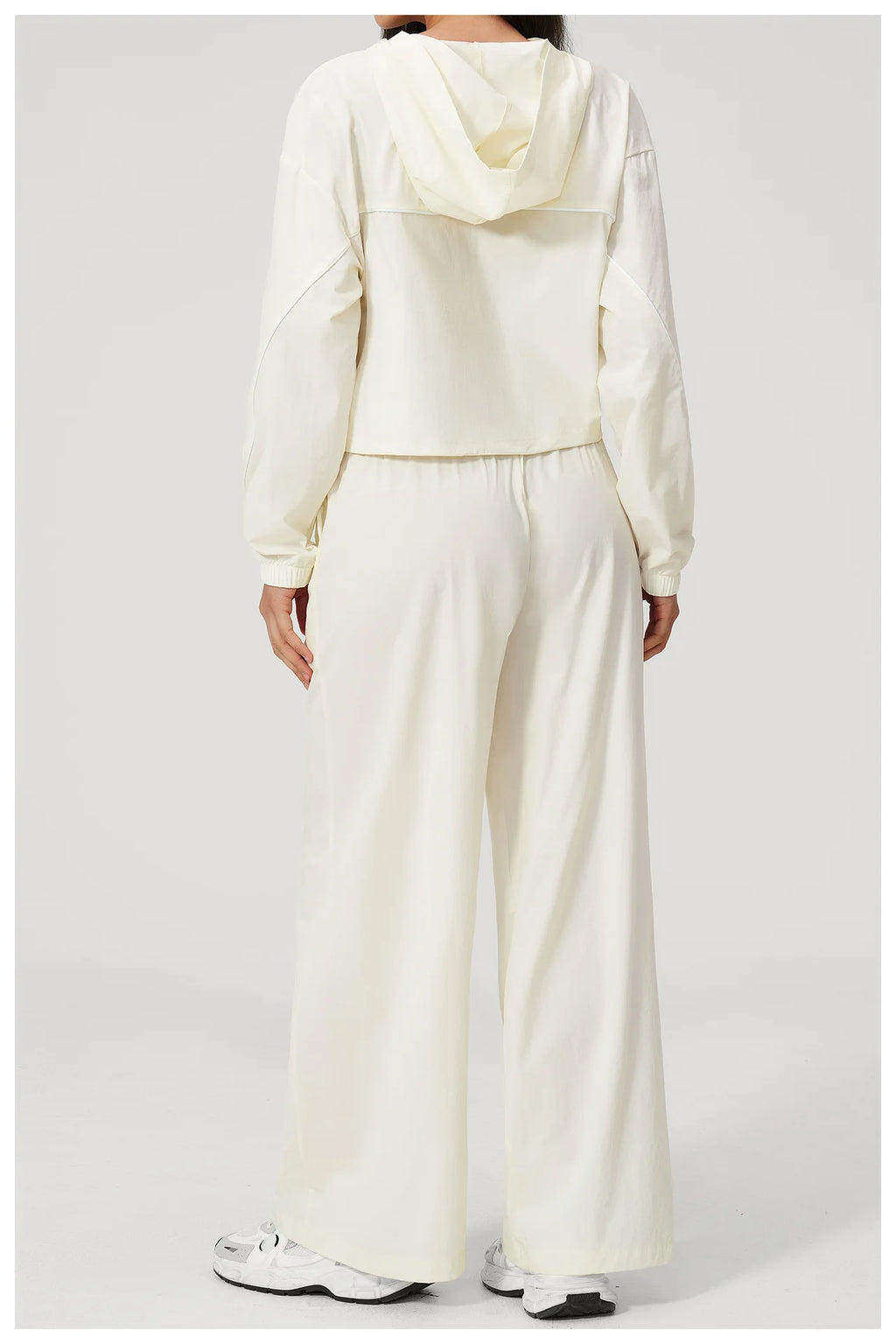 Women’s cream hooded windbreaker crop top and wide-leg pants set, back view