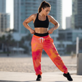 Tie-dye athletic joggers in vibrant pink and orange with white drawstring waist