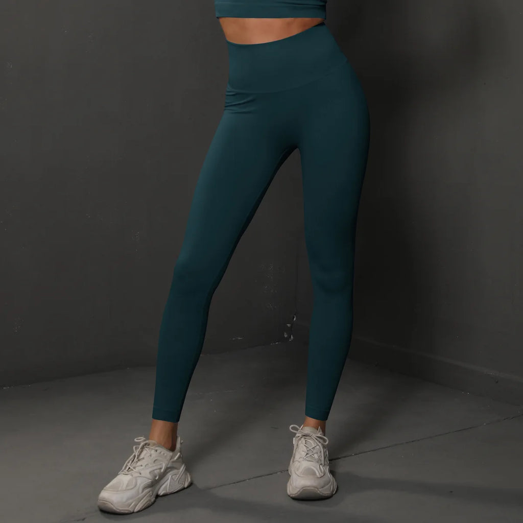 High-waist dark teal yoga leggings, full-length front side view with slim ankle fit