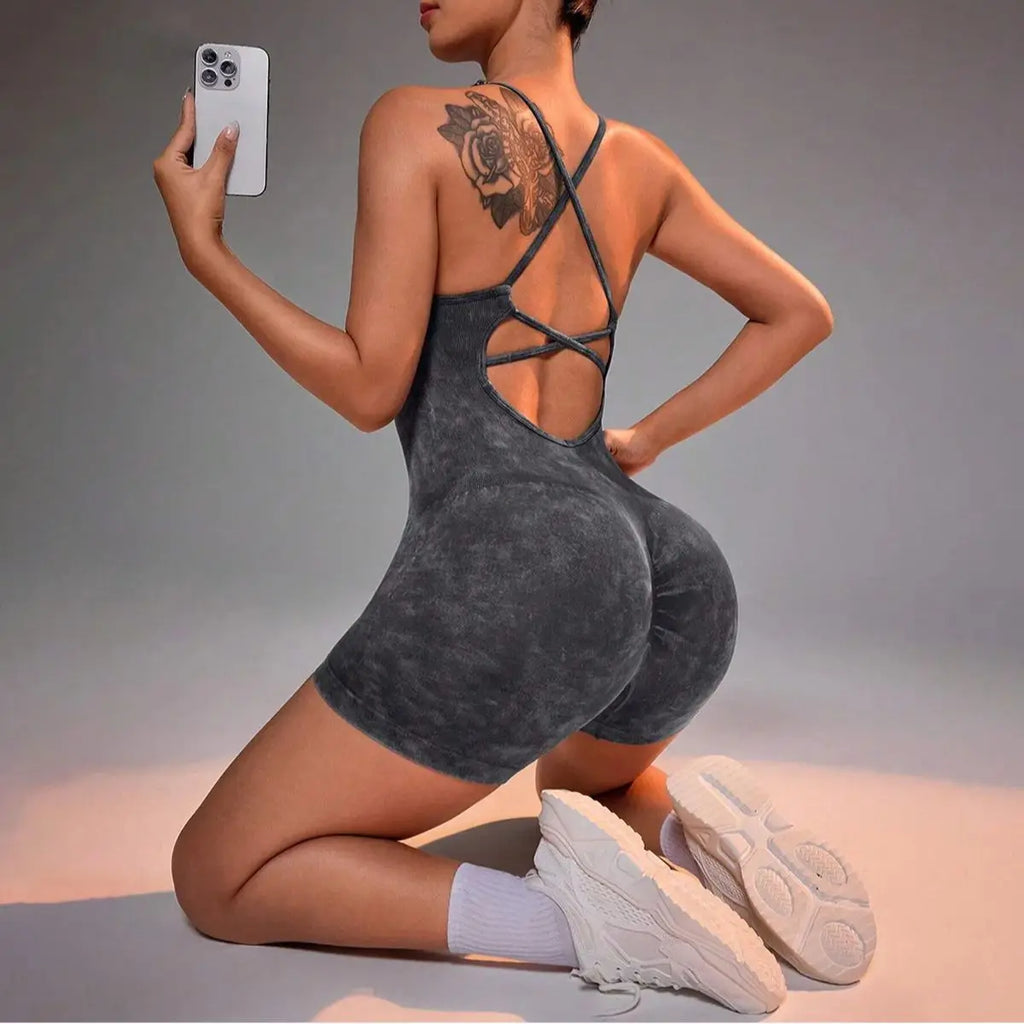 Washed black strappy yoga romper with crisscross back straps and short inseam