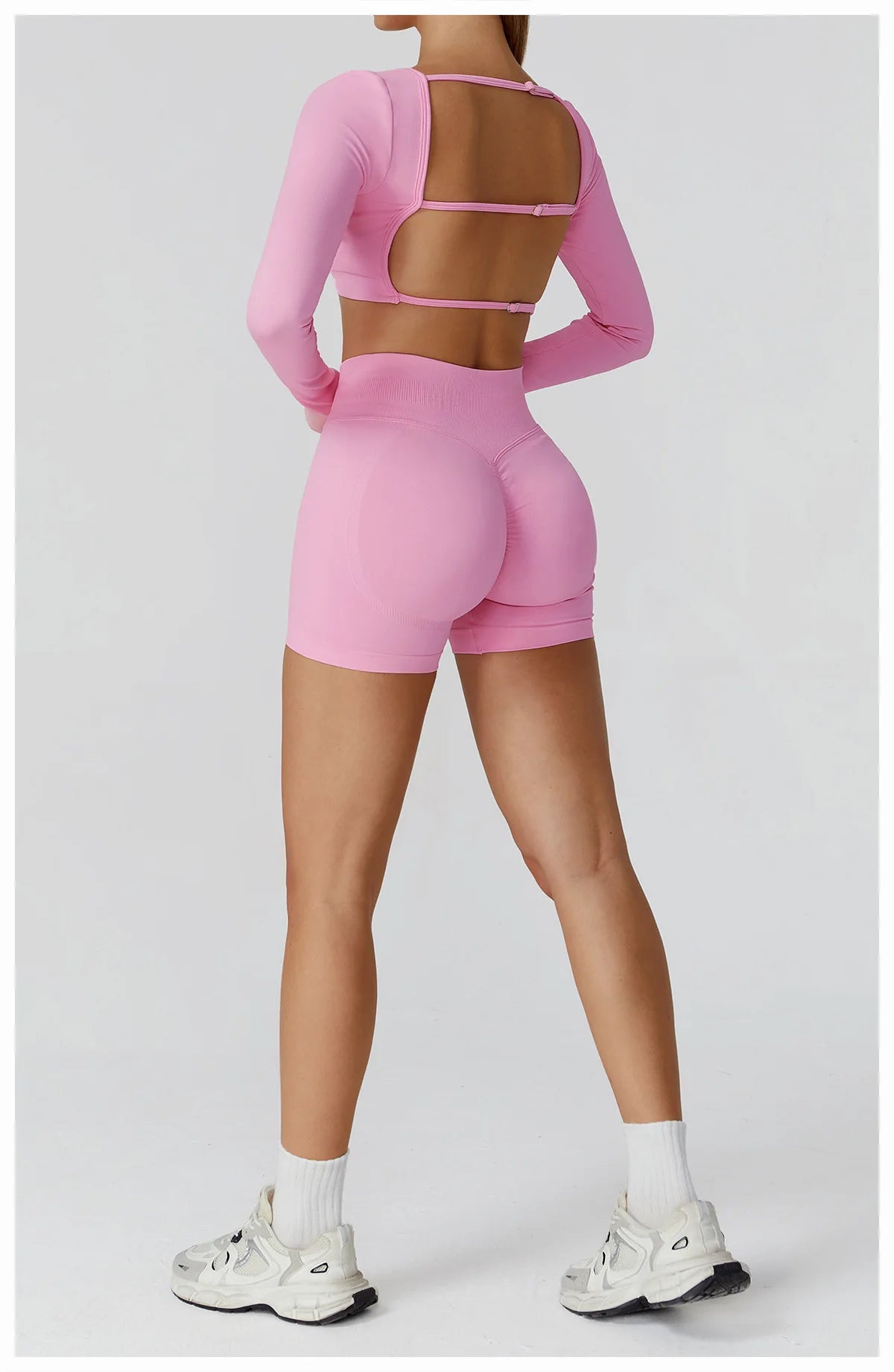 Xooie Fit Pink Two-Piece Set featuring a long sleeve gym crop top and shorts for a stylish workout look