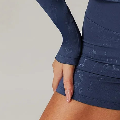 Close-up of navy embossed fitted shorts and long sleeve cuff detail
