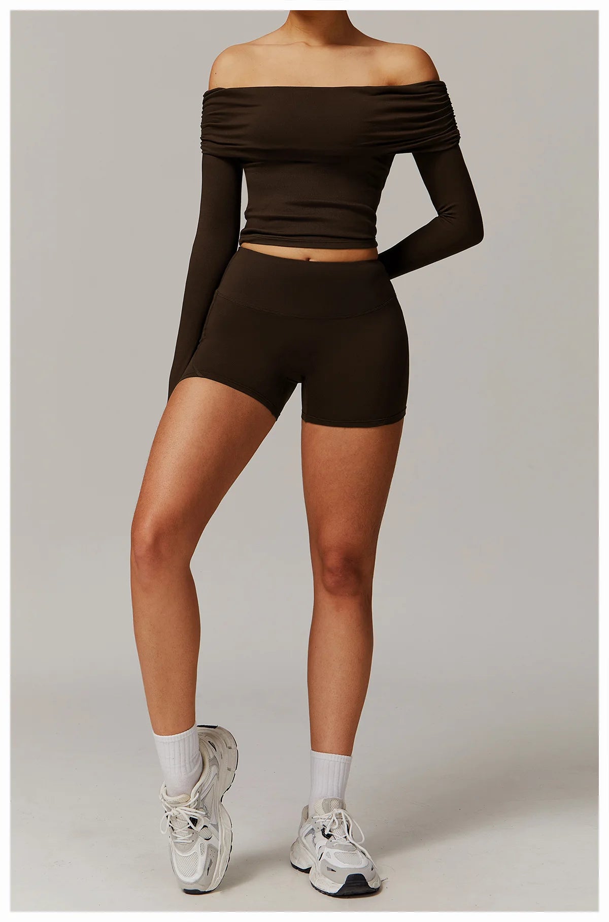 Xooie Fit brown off shoulder workout set with long sleeves and matching shorts worn with white sneakers