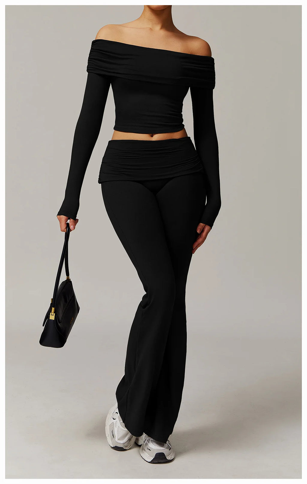 Xooie Fit black off the shoulder flare pant yoga set worn with white sneakers and a black handbag