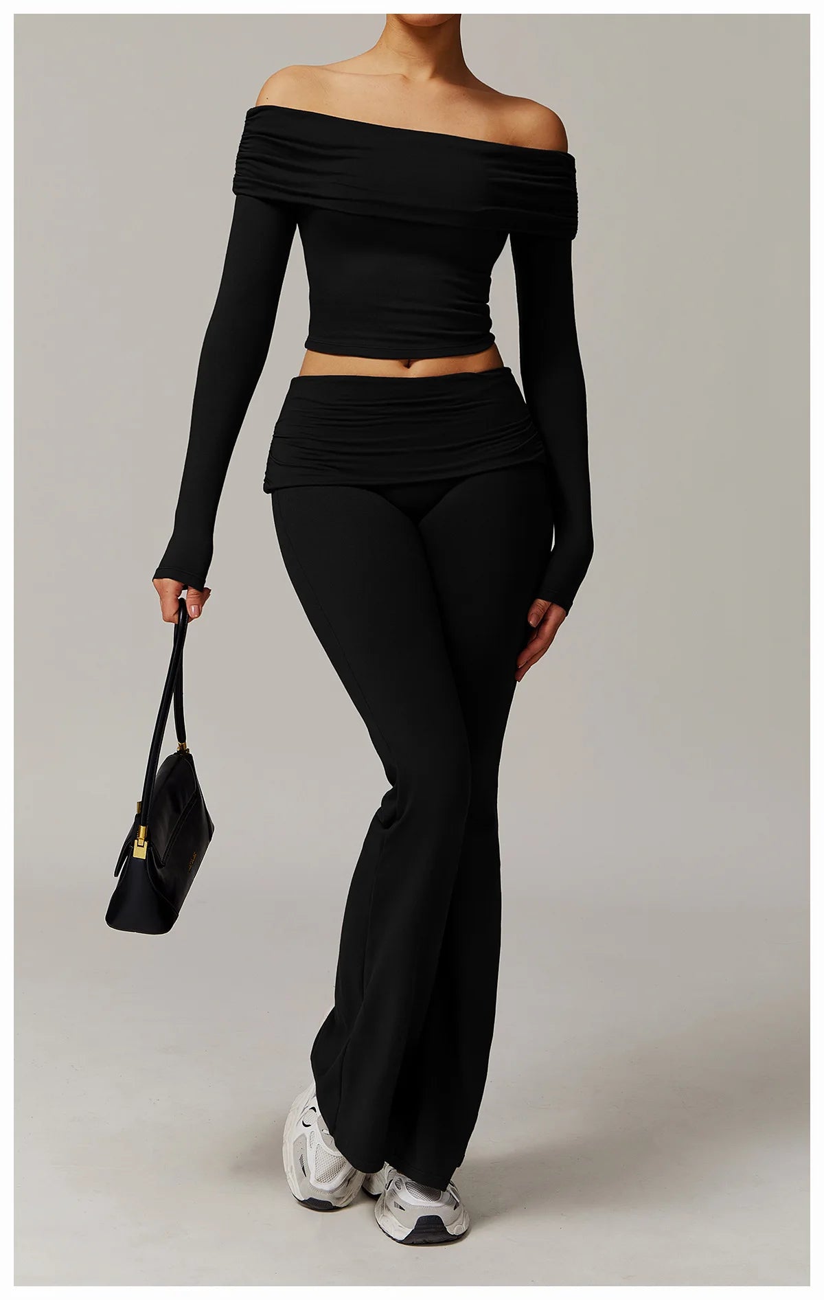 Xooie Fit black off the shoulder flare pant yoga set worn with white sneakers and a black handbag