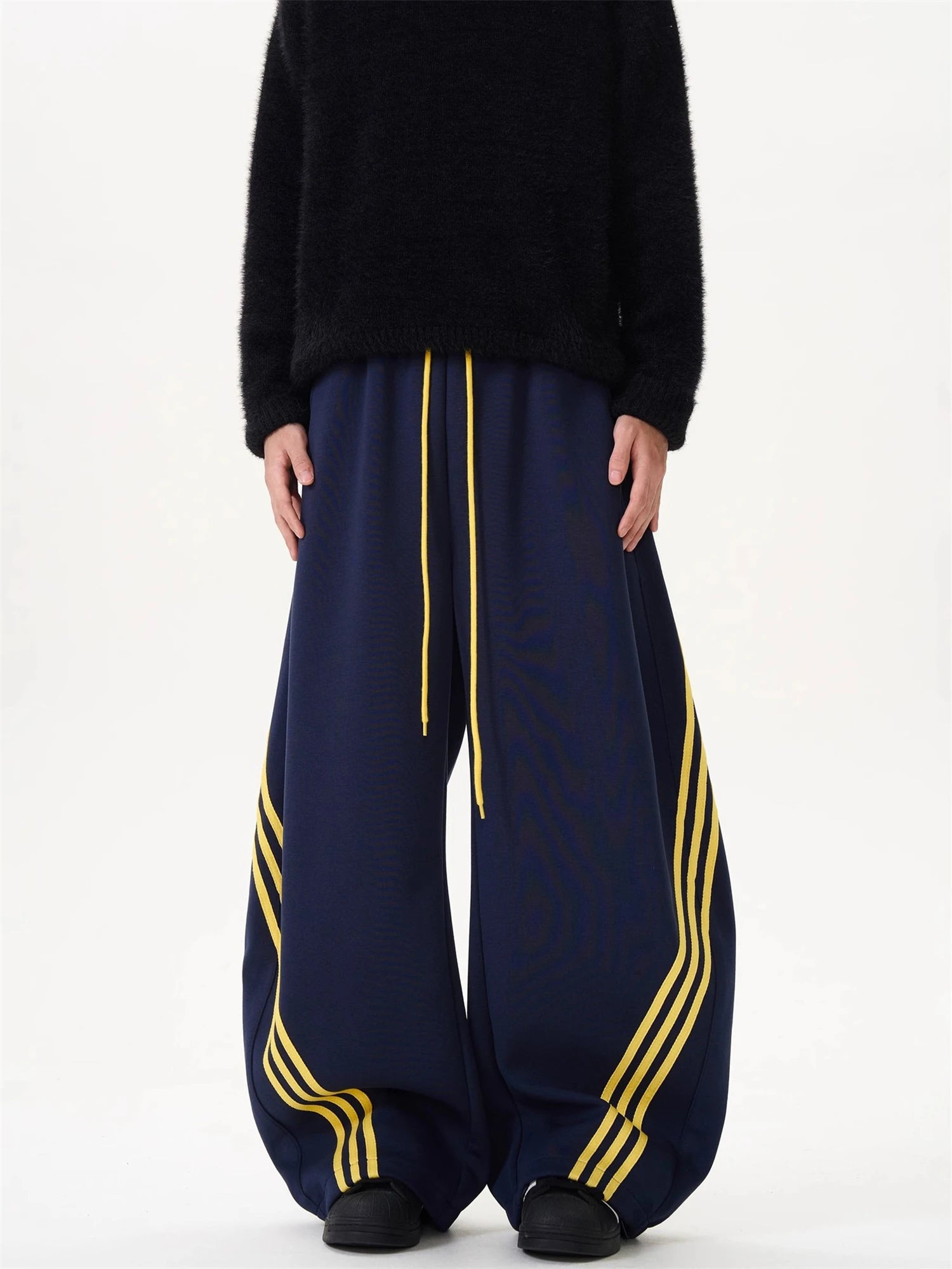 Wide-leg sweatpants, dark navy with yellow drawstring and striped side panel details.
