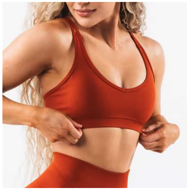 Person wearing a red sports bra and leggings on a white background