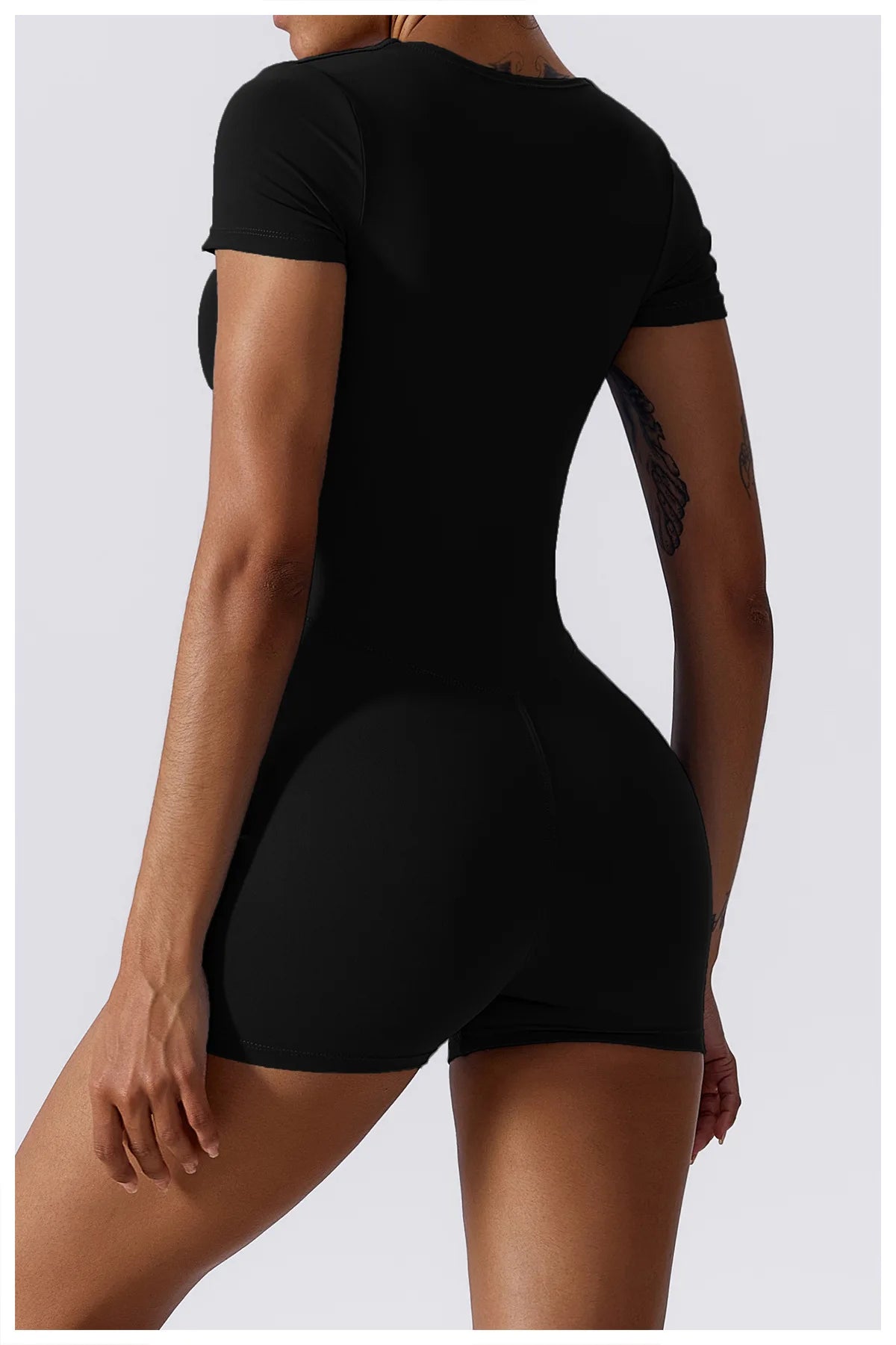 Women's black short one-piece yoga suit, back view with short sleeves