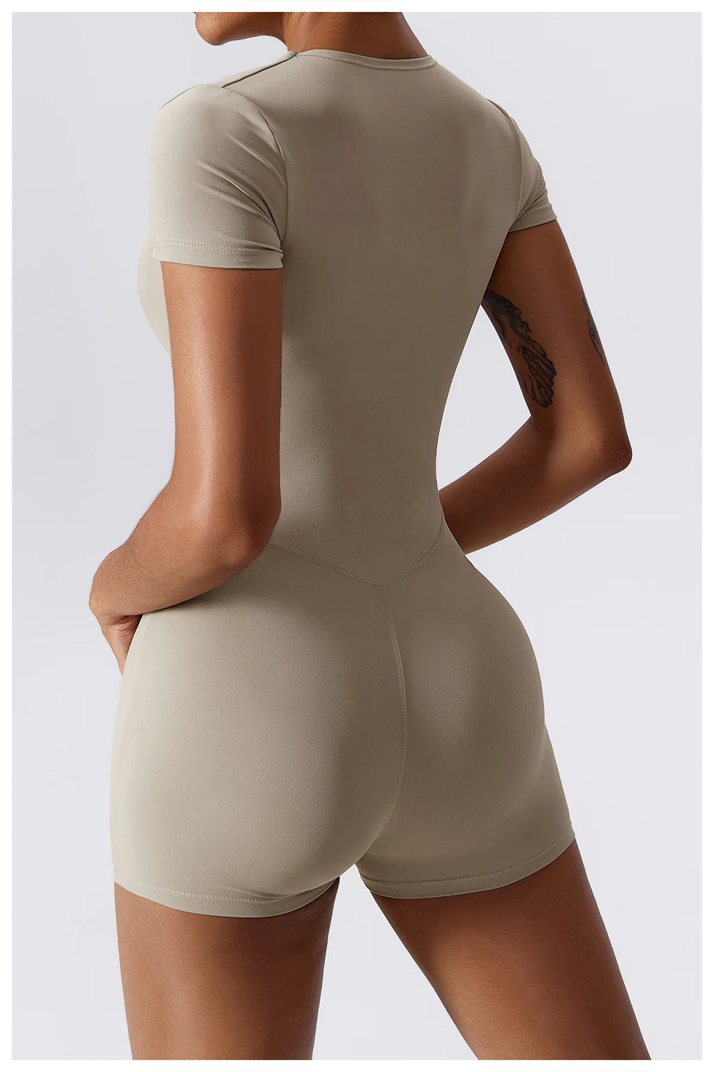 Beige short-sleeve one-piece yoga suit with racerback style and fitted shorts