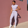 Light purple fitted active tee and leggings set, side standing pose