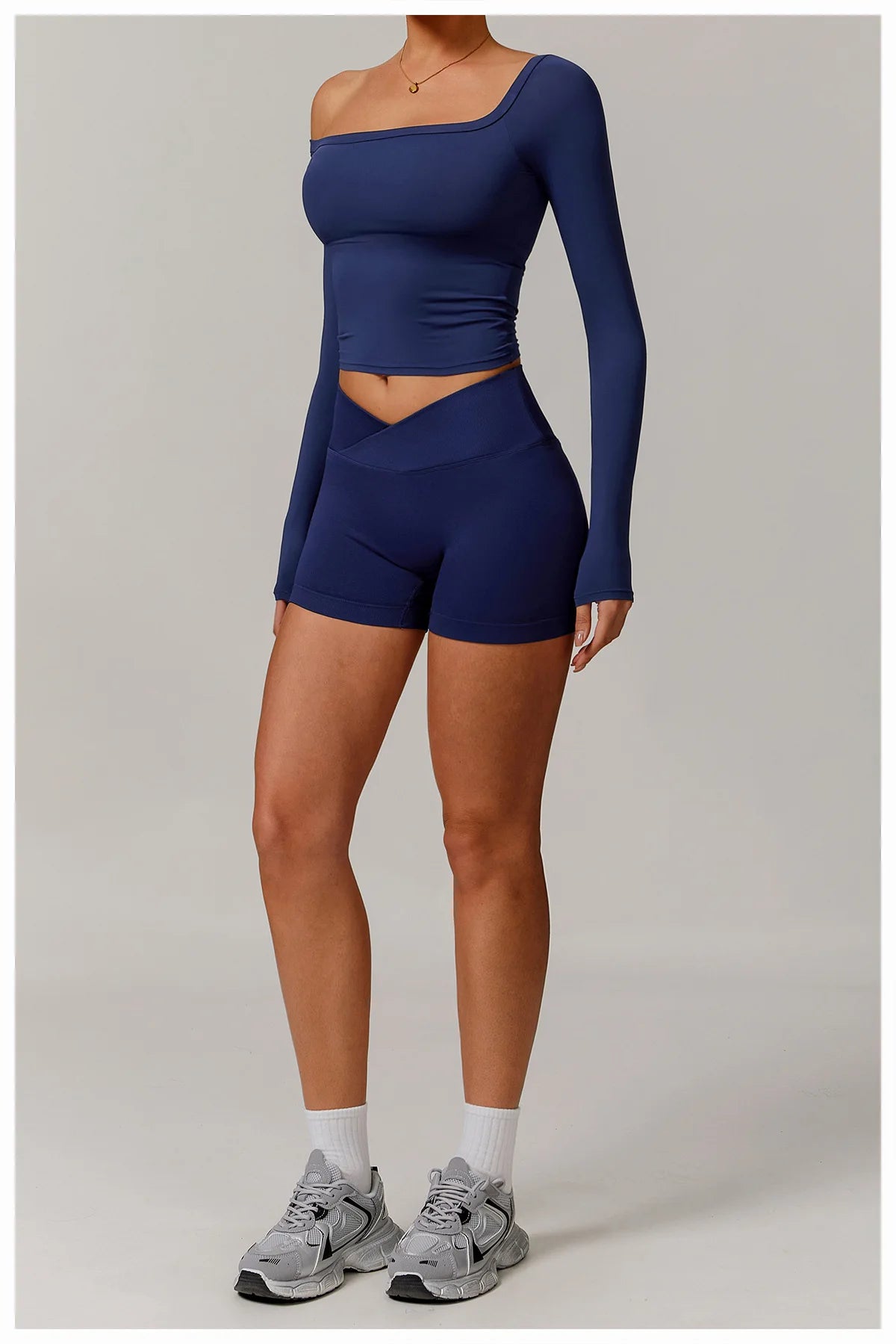 Xooie Fit stretchy long-sleeve workout shirt in navy blue with one-shoulder design worn with matching shorts