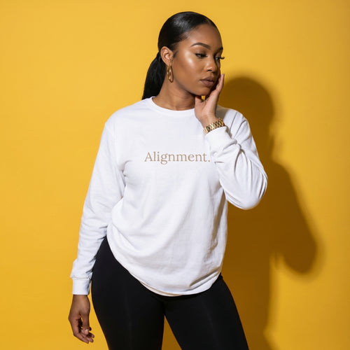 White long-sleeve tee with 'Alignment.' text graphic, model portrait view
