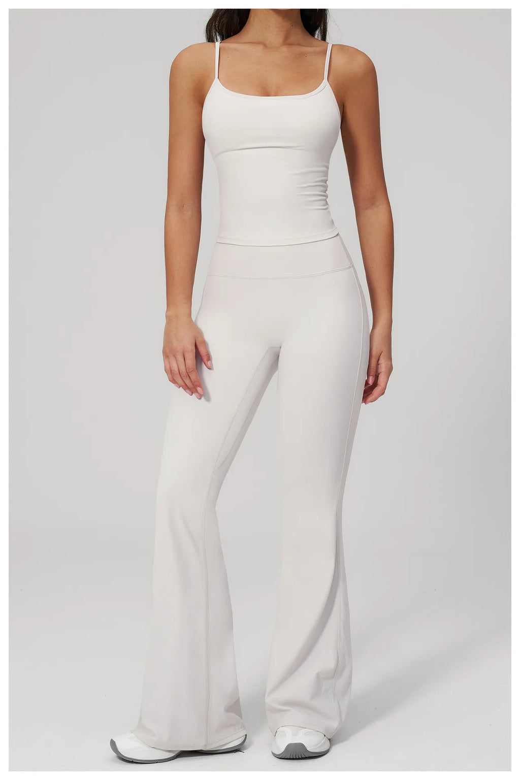 White sports set: scoop-neck tank bra and bell-leg leggings, front three-quarter