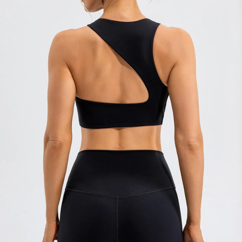 Xooie Fit unique open-back bralette in black with asymmetrical cutout on a woman from the back