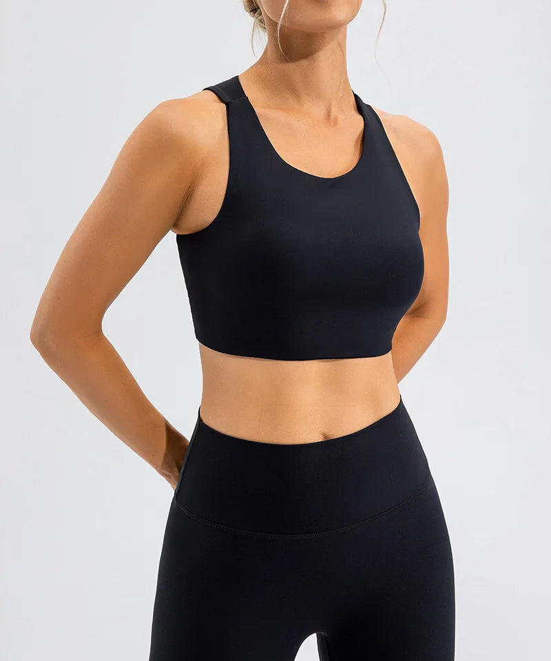 Xooie Fit black unique open-back bralette worn by model with matching high-waisted leggings