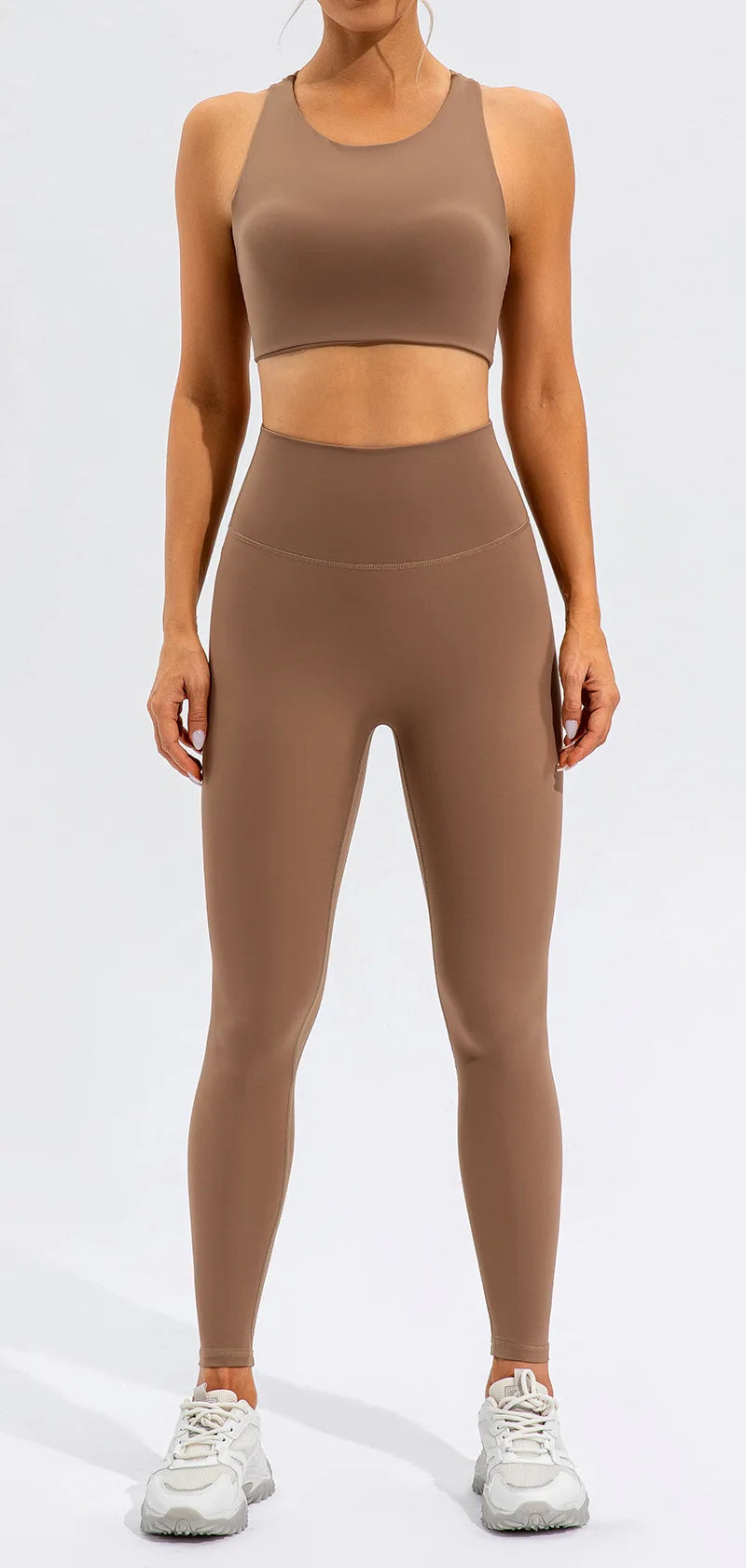 Xooie Fit unique open-back bralette in brown worn with matching high-waisted leggings and white sneakers
