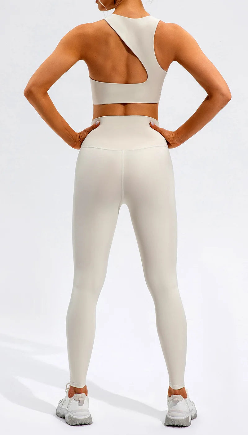 Xooie Fit unique open-back bralette in white worn by woman paired with matching leggings