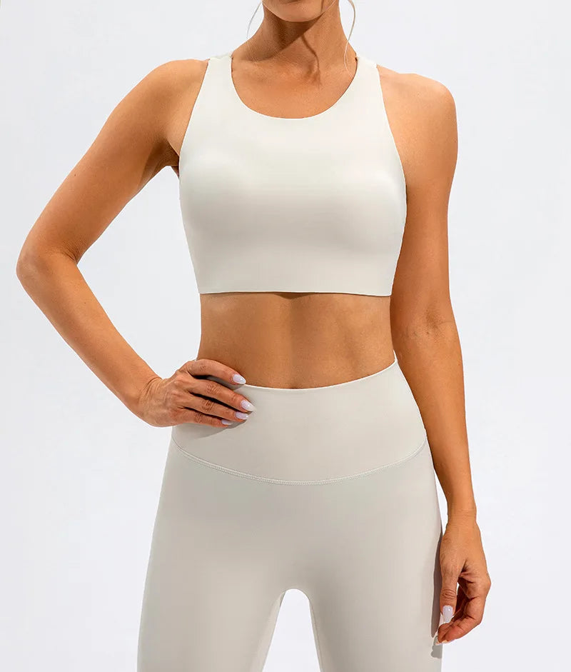 Xooie Fit unique open-back bralette in white worn by model with matching high-waist leggings