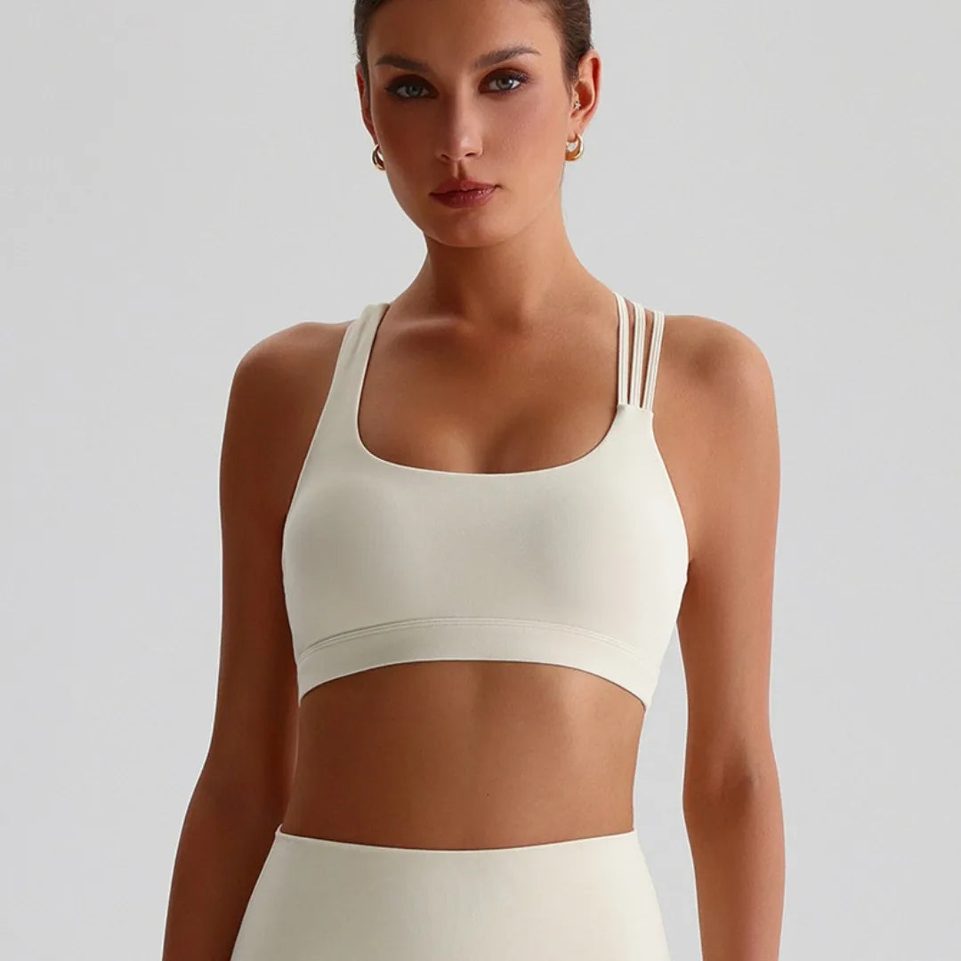 Xooie Fit unique strappy sports bra for women in cream color, designed for comfort and style during workouts