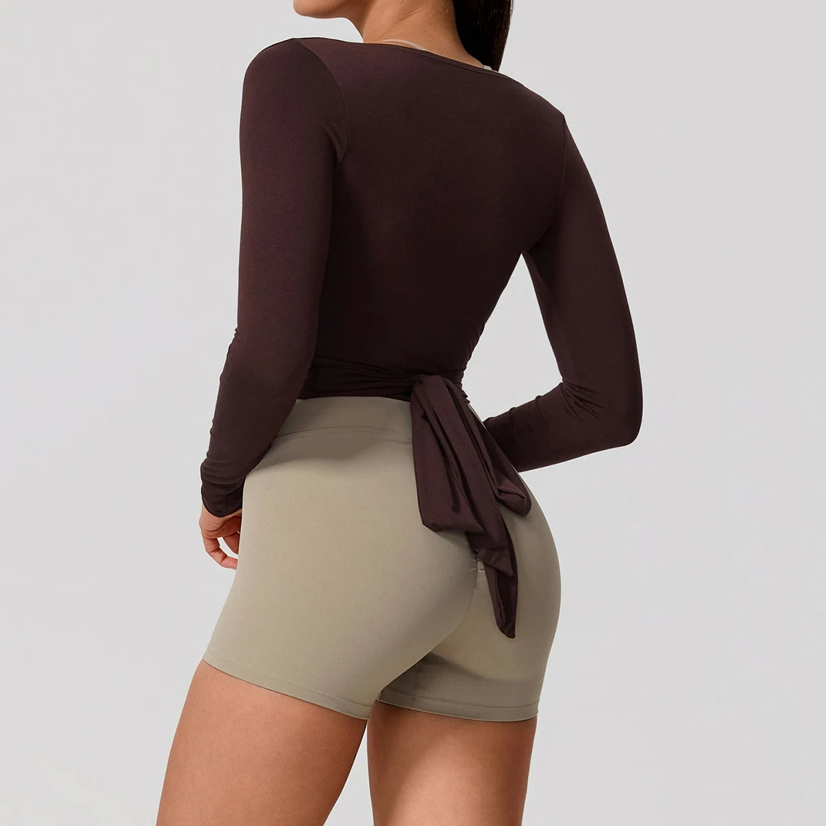 Xooie Fit Long Sleeve Wrap Top in dark brown with a tied back for a stylish look