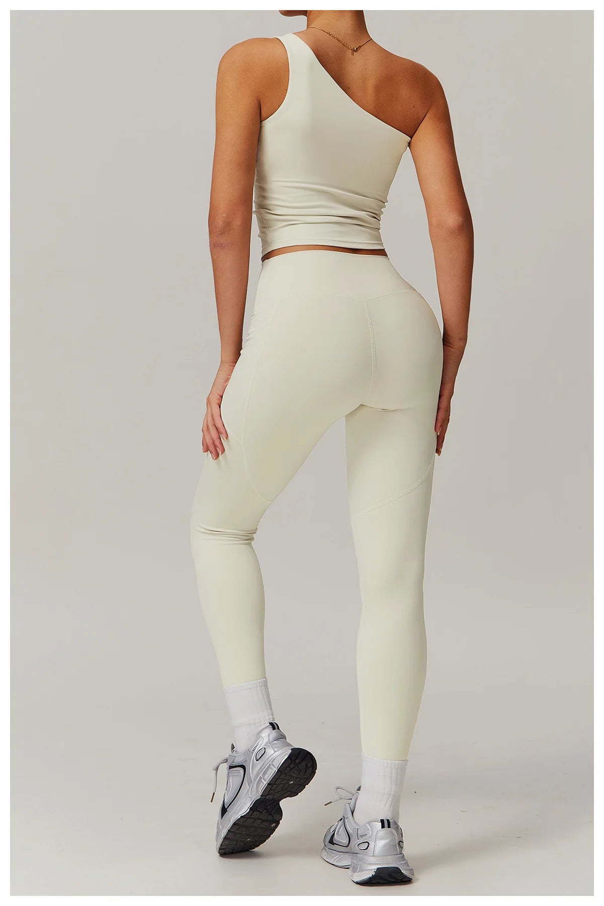 Xooie Fit one shoulder workout top in light color paired with sleek athletic leggings