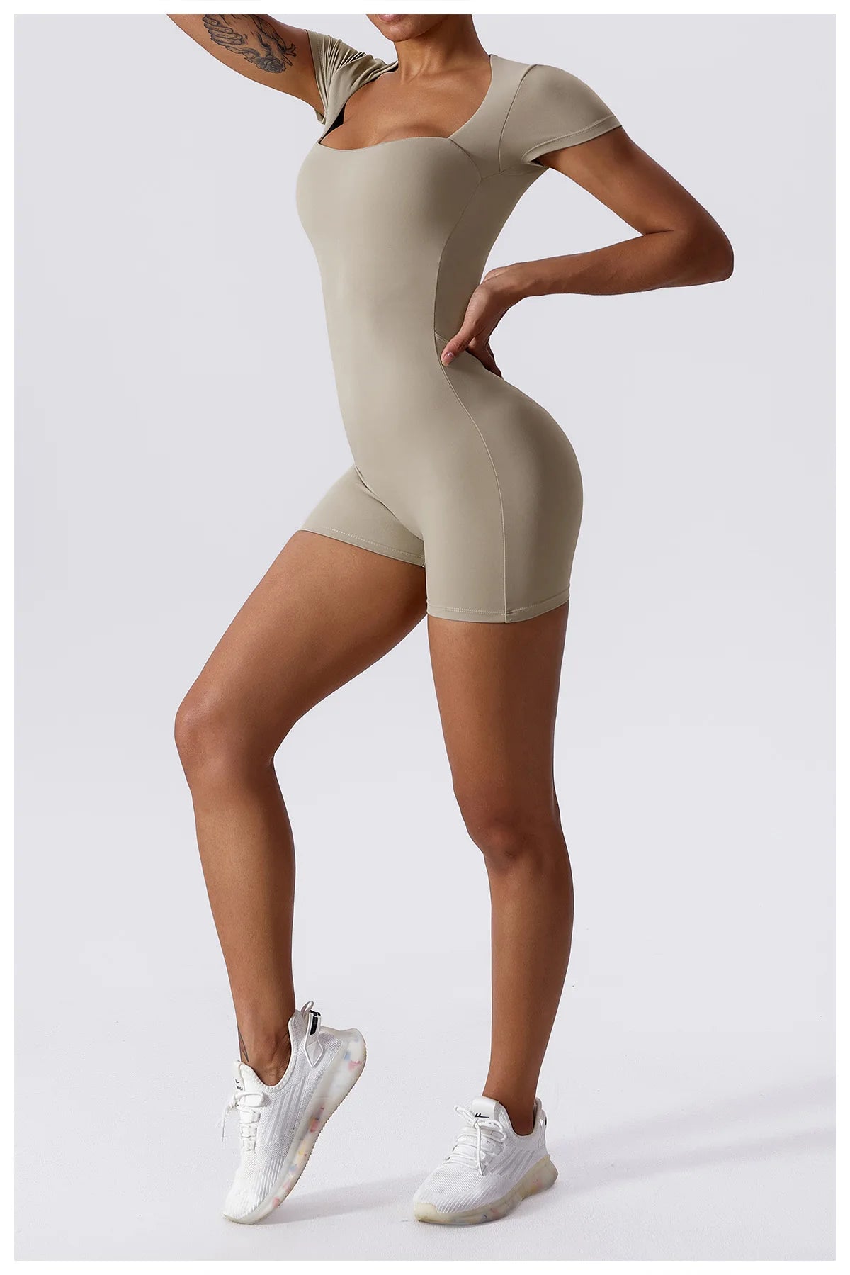 Beige short-sleeve one-piece yoga suit with fitted shorts and crew neckline