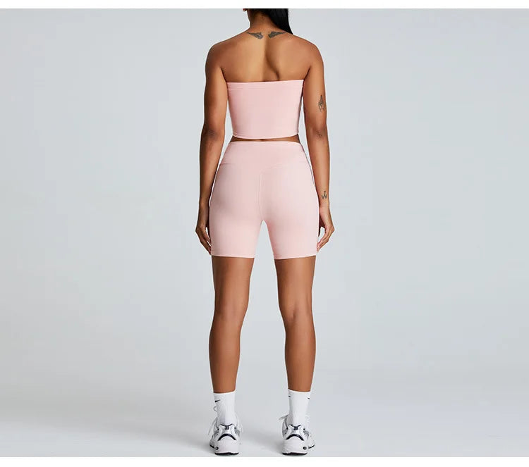 Xooie Fit strapless activewear set in light pink, featuring a cropped top and high-waisted shorts