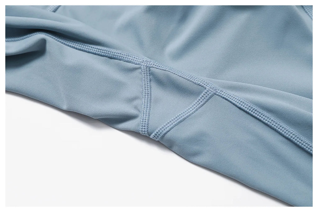 Close-up of Xooie Fit women's two-piece workout set in light blue fabric showcasing stitching details