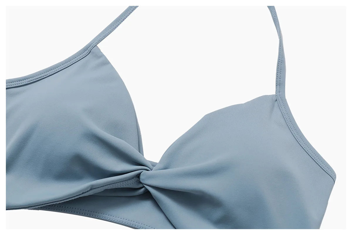 Xooie Fit women's two-piece workout set in soft blue with stylish twist design on the top