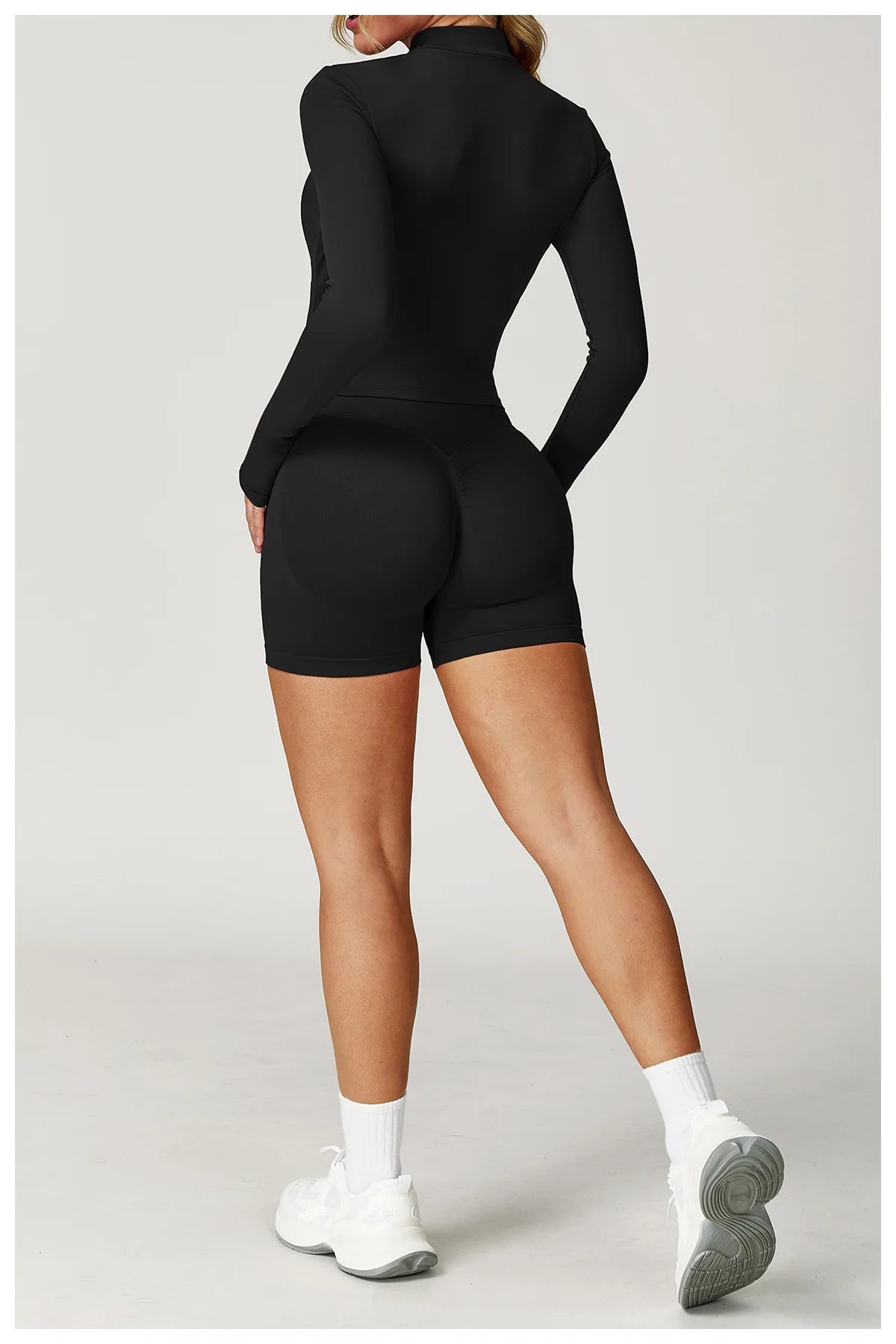 Black fitted zip jacket and matching active shorts set, back view