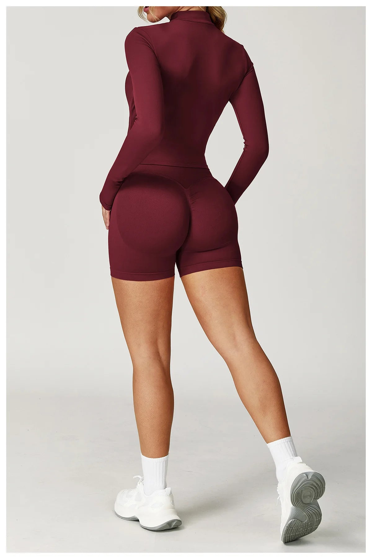 Maroon fitted zip jacket and matching active shorts set, back view