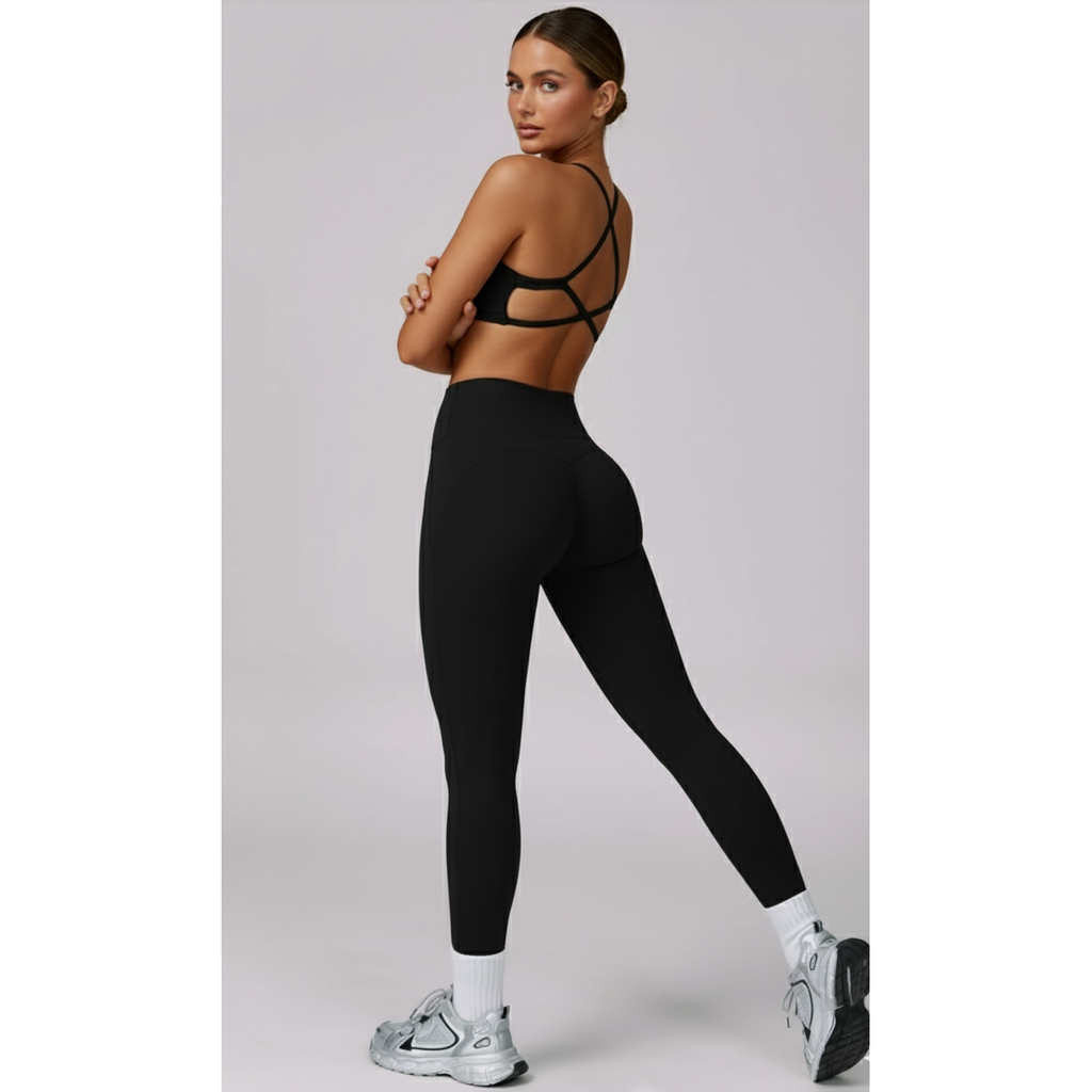 Woman wearing a black sports bra and leggings on a light gray background