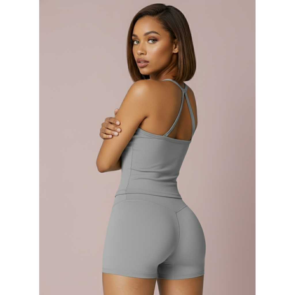 Woman wearing a gray tank top and shorts set on a beige background