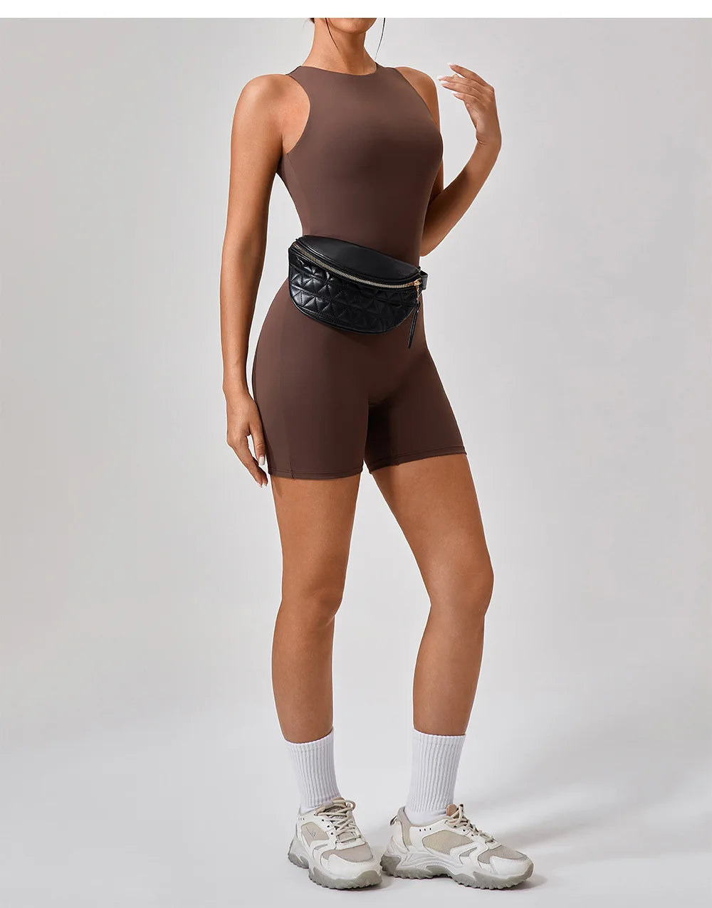 Hauncha brown active romper with sleeveless design and front center seam.
