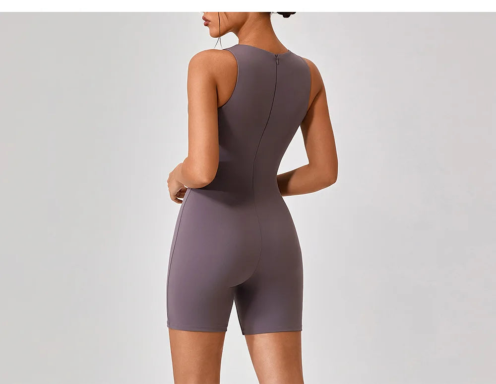 Purple active romper back view with center back zipper and fitted shorts.