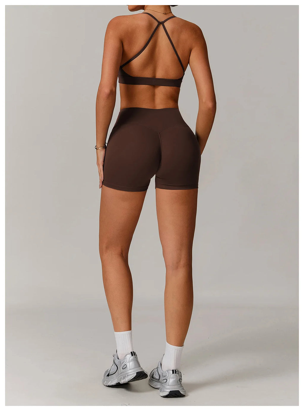Xooie Fit women's active shorts in dark brown shown from the back with matching sports bra and running shoes