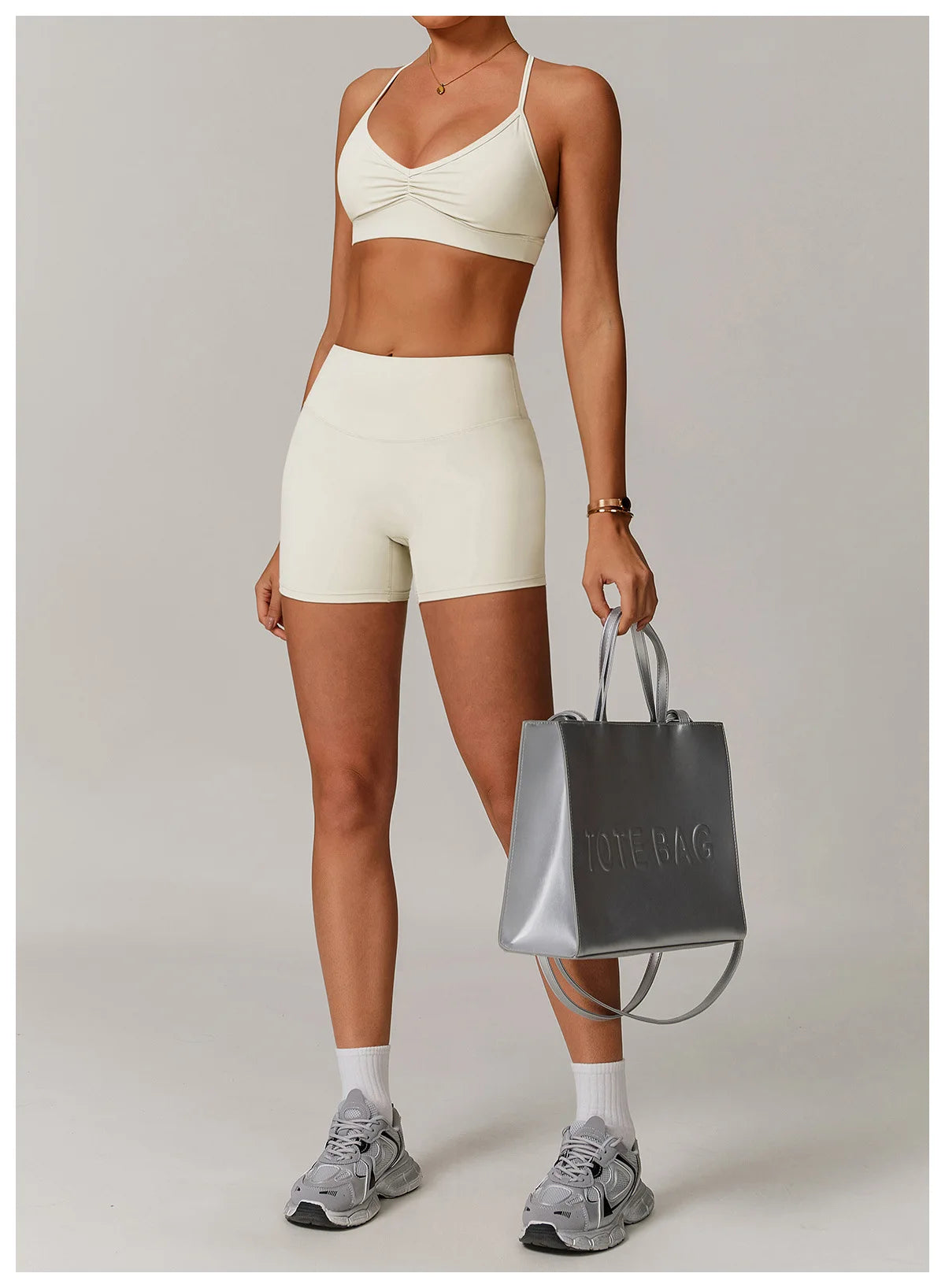 Xooie Fit women's active shorts in cream color paired with matching sports bra and sneakers
