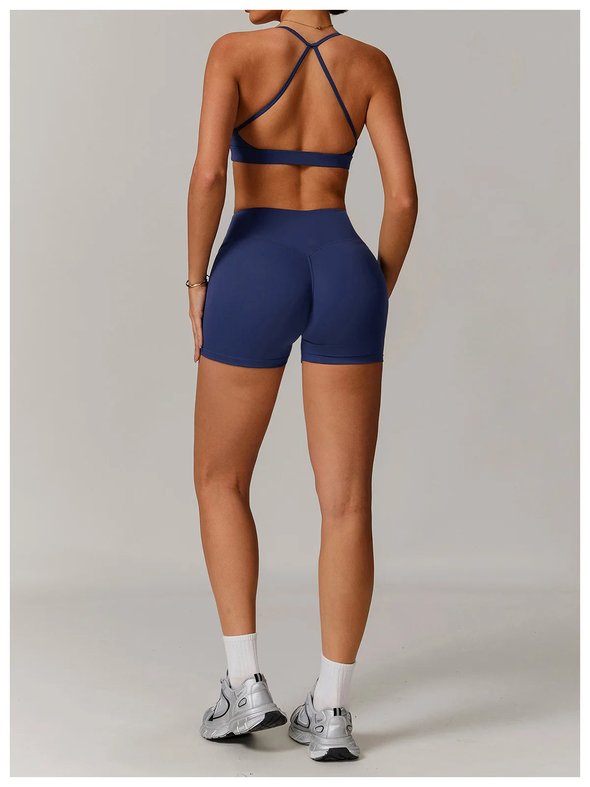 Xooie Fit navy women's active shorts worn with matching sports bra and running shoes
