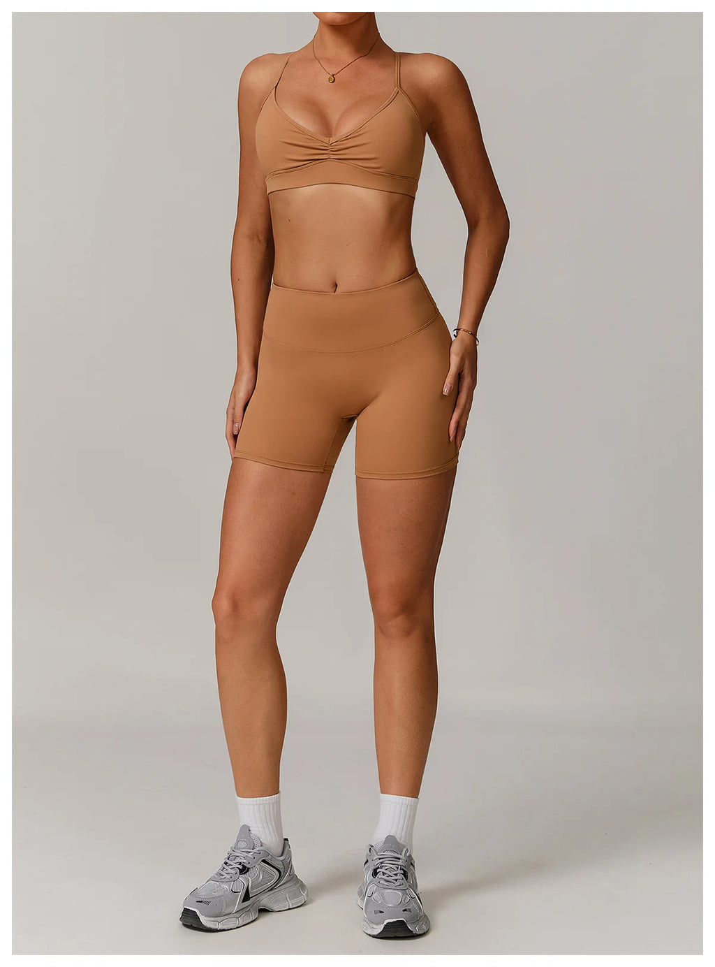 Xooie Fit women's active shorts in tan color paired with matching sports bra and gray sneakers