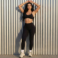 Black high-waisted leggings with matching active bra, full-body front view