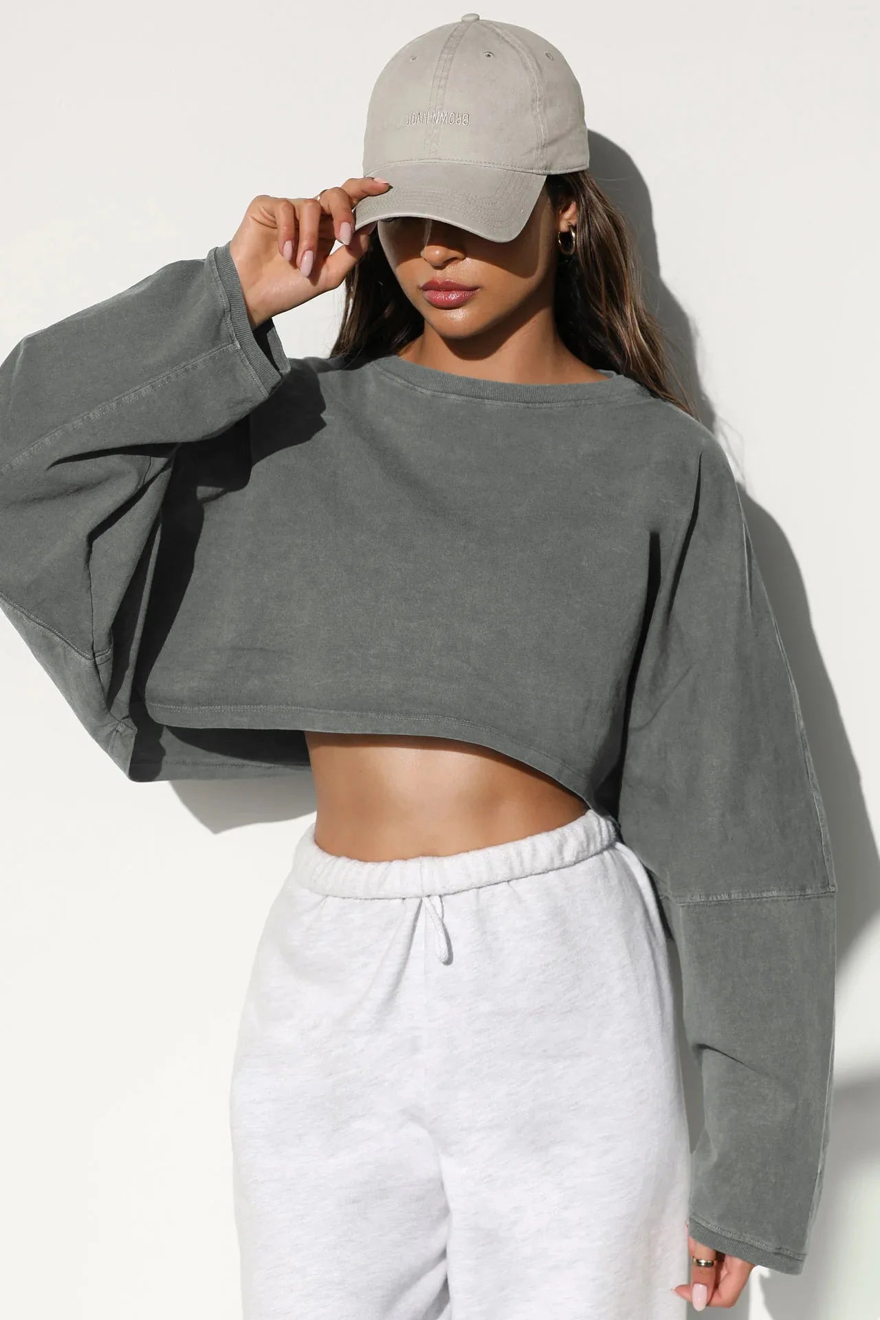 Xooie Fit women's baggy crop top in gray with long sleeves, styled with casual pants and a hat