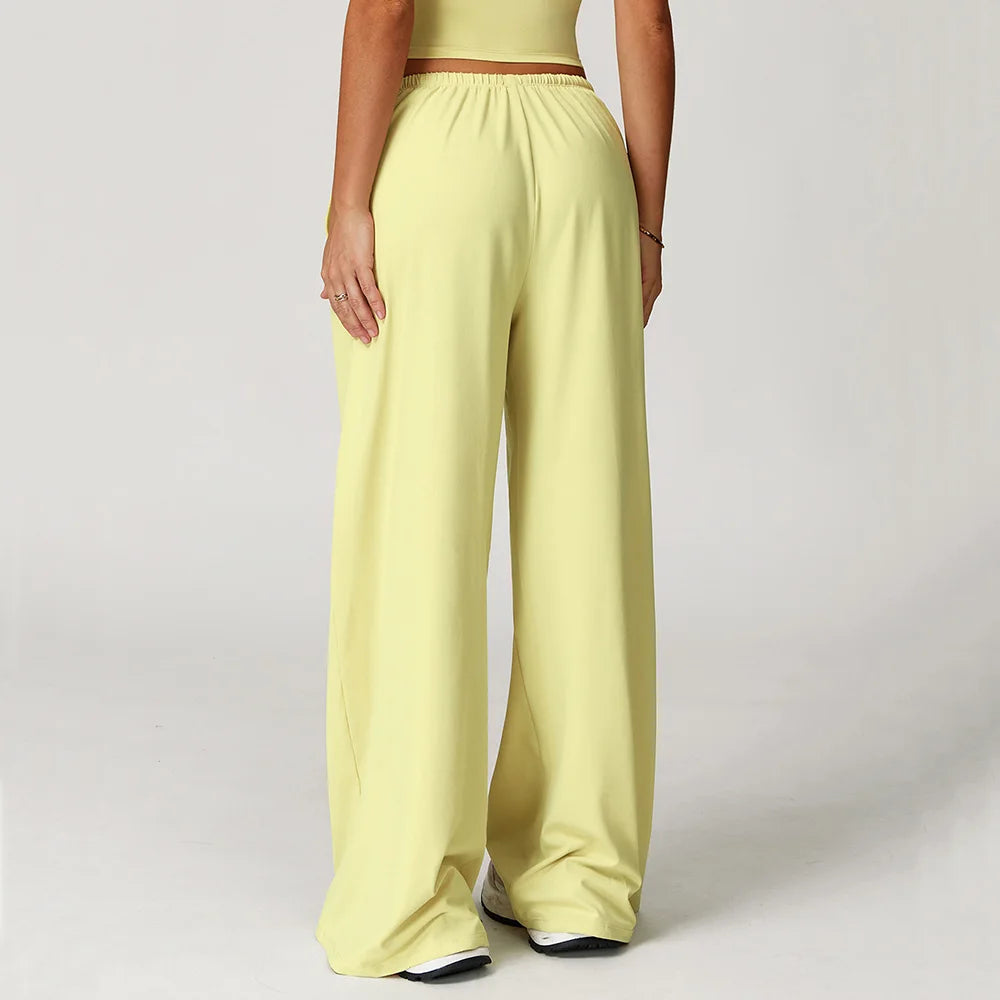 Back view of women's baggy workout pants from Xooie Fit in light yellow with a comfortable waistband