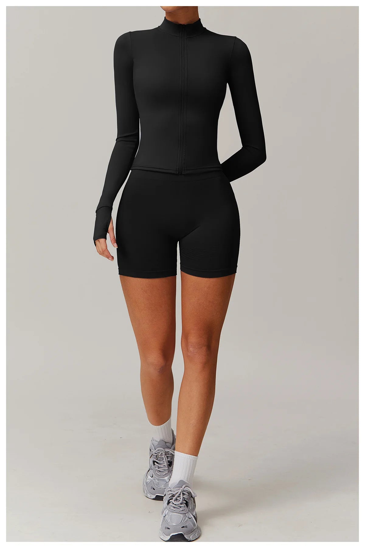 Xooie Fit women's fitness jacket with thumb holes in black, paired with matching black shorts