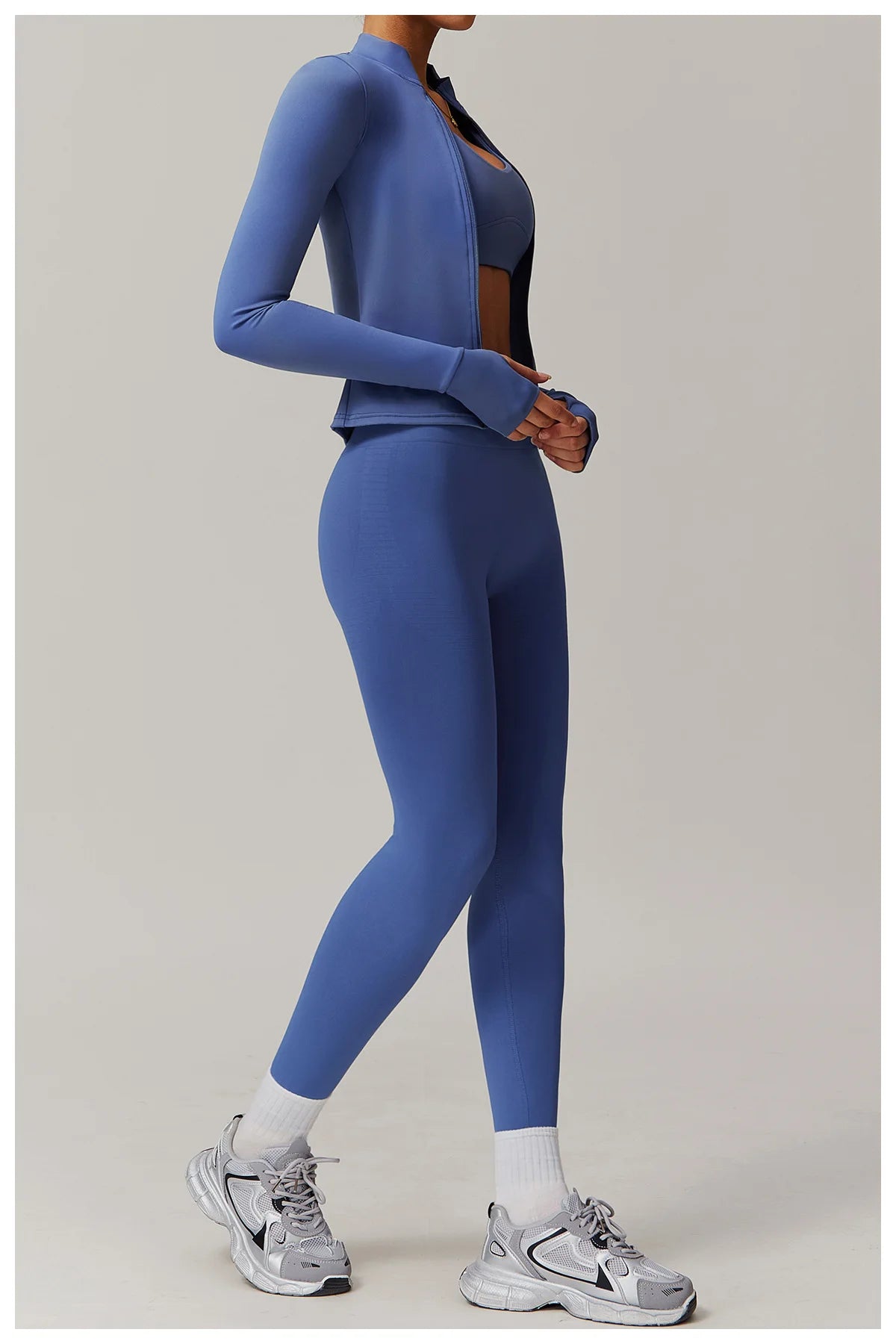 Xooie Fit women's fitness jacket with thumb holes in blue paired with matching leggings and sneakers