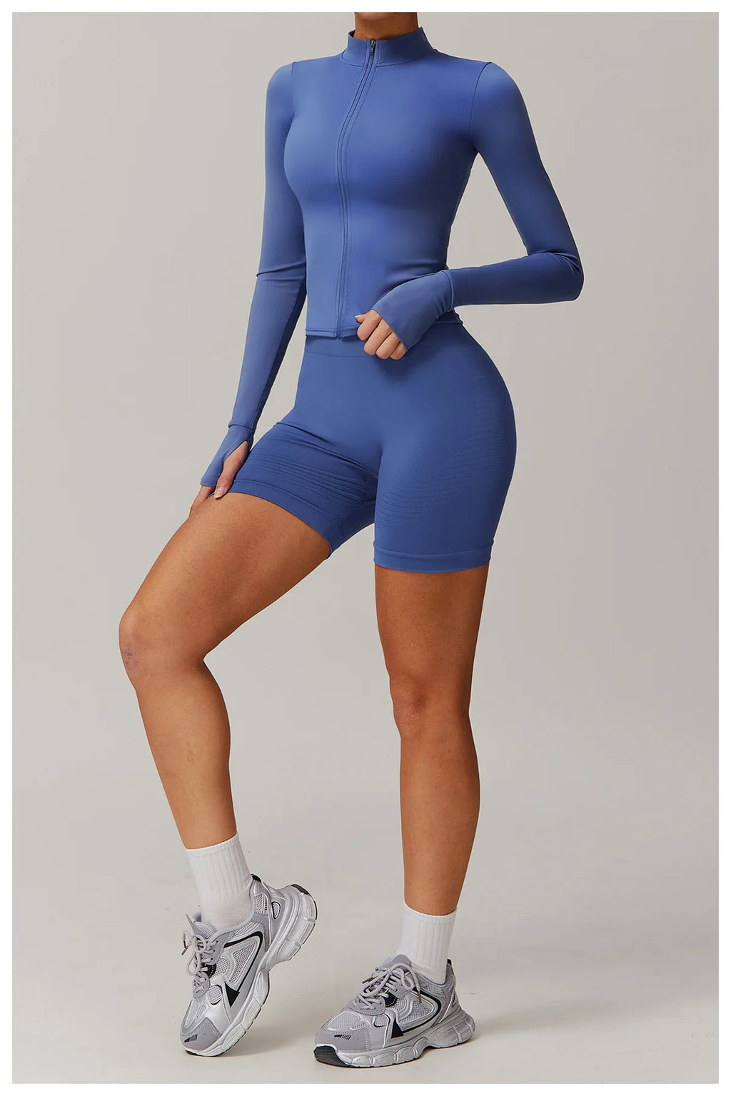 Xooie Fit women's fitness jacket with thumb holes in blue, paired with matching shorts and sneakers